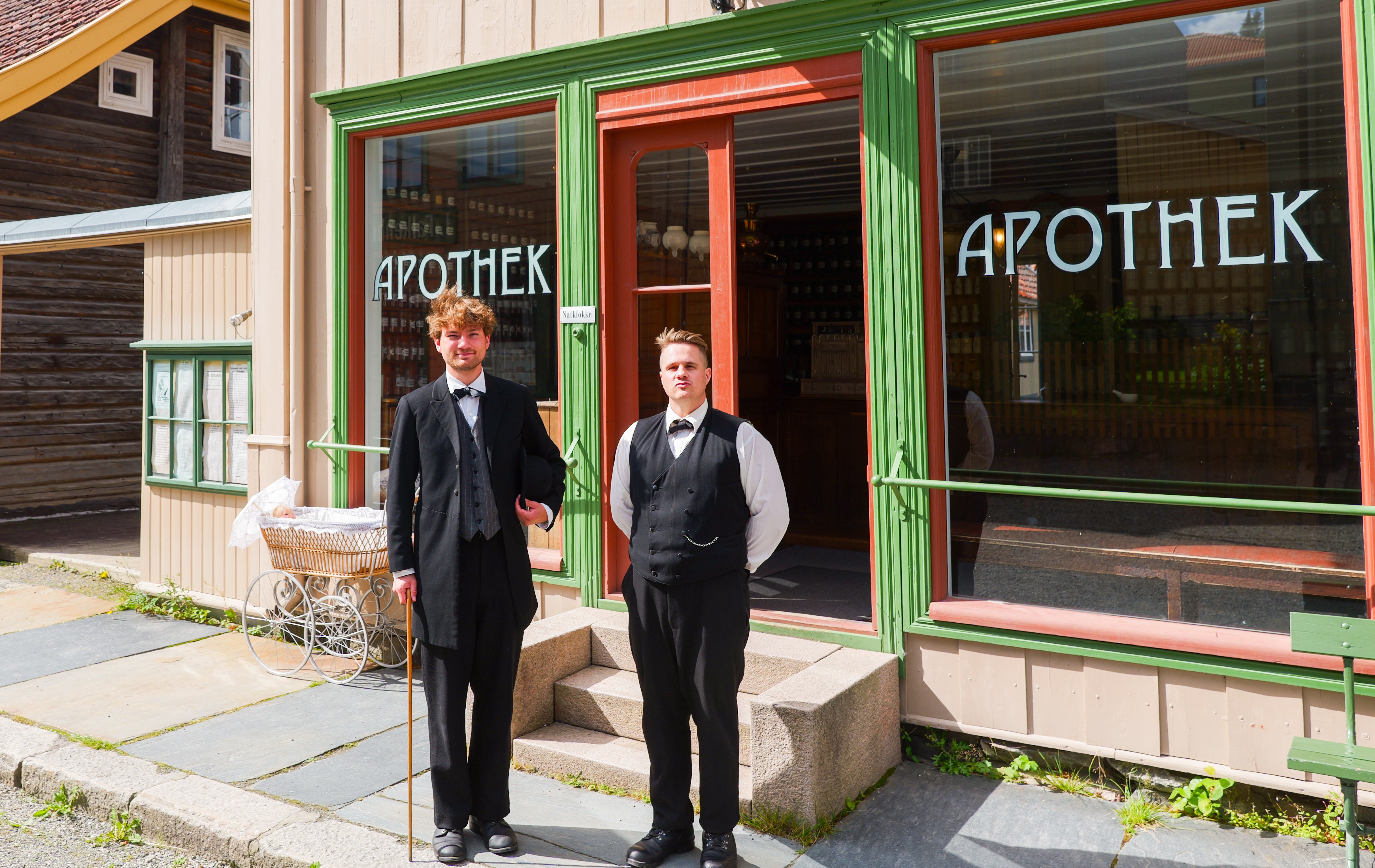 To museumsguider foran historisk butikk i den gamle byen på Maihaugen friluftsmuseum i Lillehammer