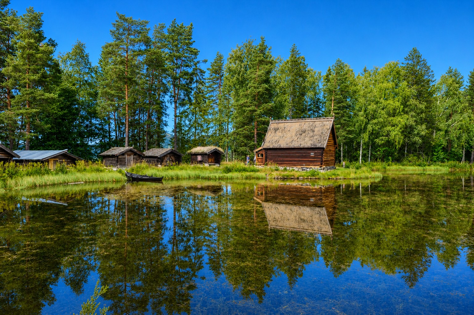 Gamle hus foran et vann på Maihaugen Friluftsmuseum