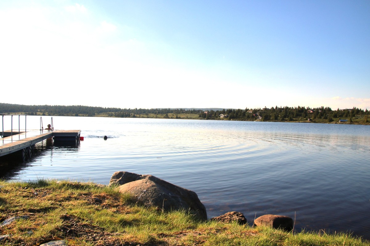 Badebrygge ved Nevelvann med utsikt mot fjellet