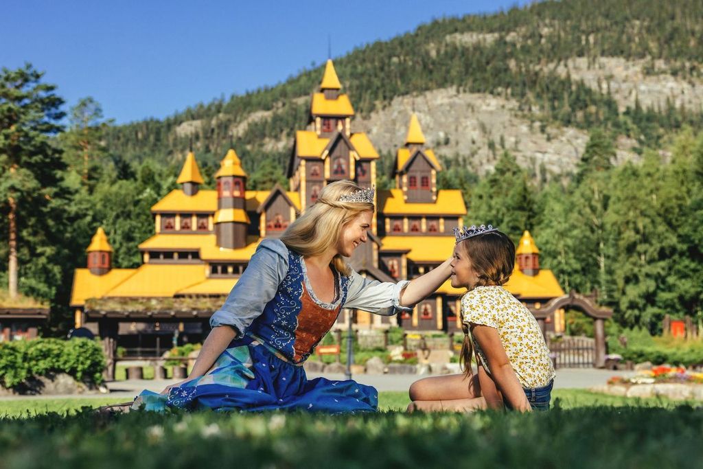 Prinsesse og liten jente foran Eventyrslottet i Hunderfossen