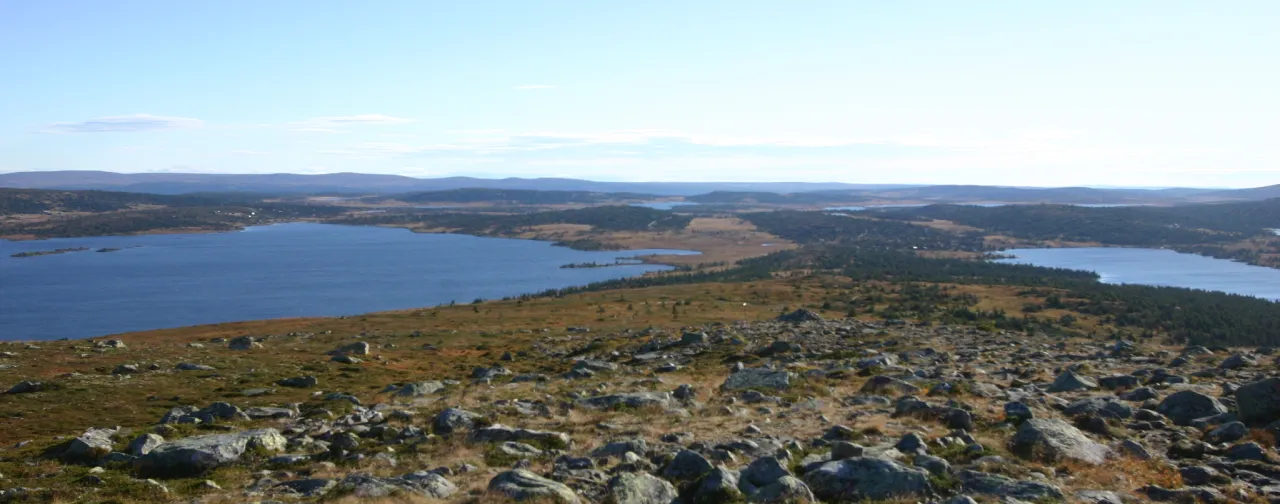 et stort steinete landskap med en vannmasse i bakgrunnen