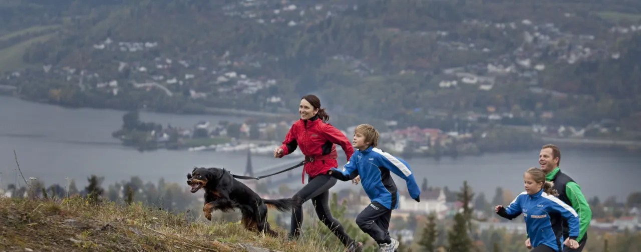 Familie med hund som løper i terrenget i Lillehammer