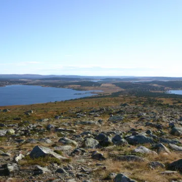 et stort steinete landskap med en vannmasse i bakgrunnen