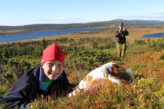Gutt og hund som koser seg i høstlyngen på Nordseter ved Lillehammer Fjellstue