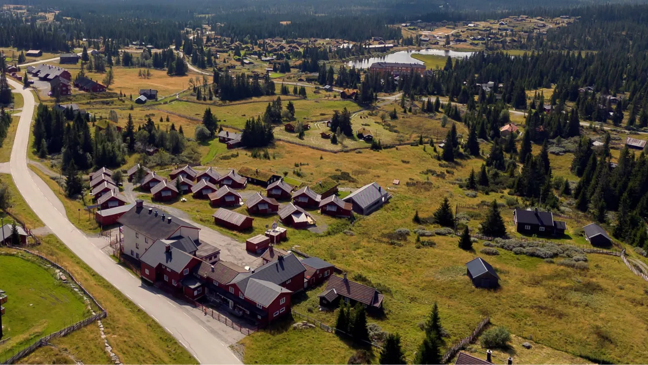 Lillehammer Fjellstue med hyttene og vann i bakgrunnen